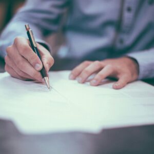 Seorang pria sedang menandatangani sebuah dokumen dalam artikel perbedaan shm dan shgb