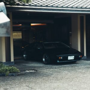 Sebuah mobil yang sedang parkir di garasi dalam artikel carport minimalis di Ecotown.id