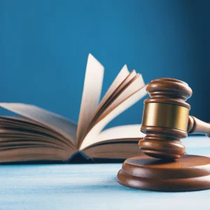 Buku dan palu hakim dalam artikel legalitas perumahan yang wajib dicek di website ecotown.id