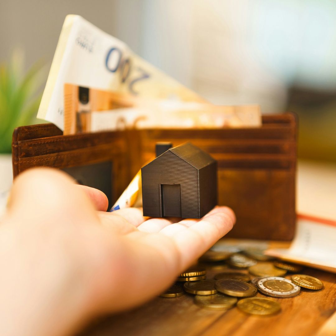 Miniatur rumah disebelah dompet berisi uang dalam artikel proyeksi harga properti 5 tahun ke depan di website ecotown.id