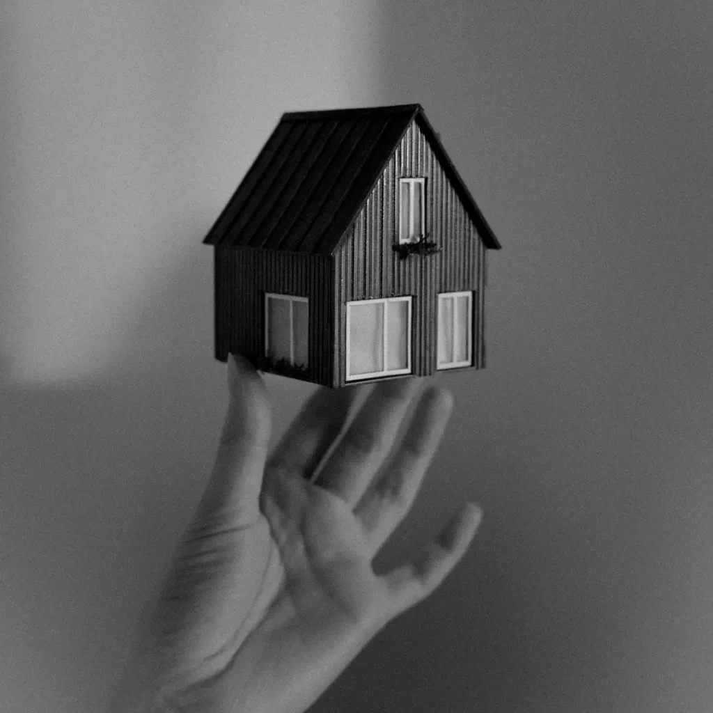 Tangan manusia sedang memegang miniatur rumah dalam artikel Beli Rumah di Sawangan di website ecotown.id